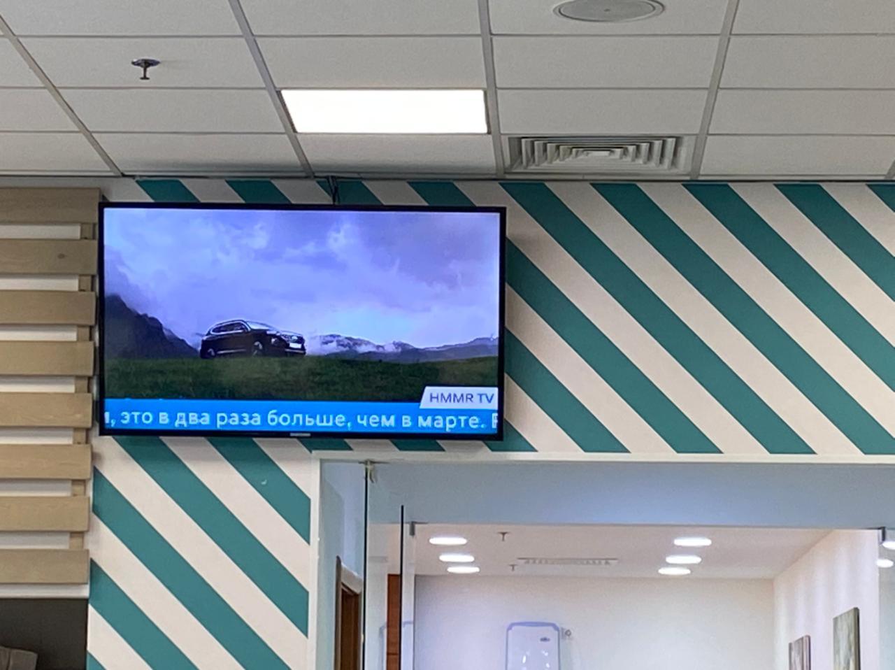 Corporate TV display in automotive factory assembly area showing company news, shift schedules, and production targets via SpinetiX player