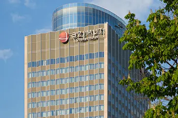 Hotel lobby with elegant digital signage display showing guest welcome messages, restaurant menus, and local attractions powered by SpinetiX