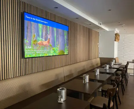 Hotel Adler in Friedrichshafen with SpinetiX infotainment displays showing local events, weather forecasts, and guest services information