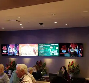 Reception desk area at Soboba Casino Resort with digital welcome screens displaying guest check-in information, promotions, and loyalty program details