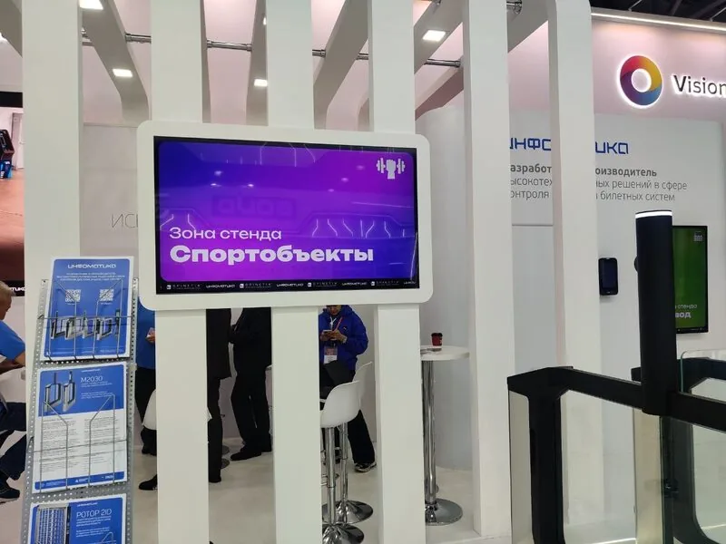 SpinetiX × Infomatika joint booth at Securika Moscow 2026 with screens and turnstiles on a live demo floor